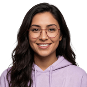 Young woman with long dark hair, wearing glasses and a light purple hoodie, smiling at the camera against a plain white background.